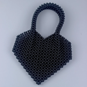 Vista dall'alto della borsa fatta a mano con perle nere a forma di cuore intrecciato