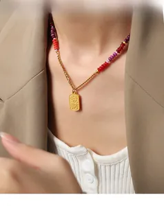 Detail of vintage gold-plated necklace with Chinese character pendant and colorful beads