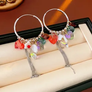 Boucles d'oreilles créoles cœur en cristal avec pampilles colorées sur boîte cuir