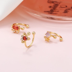 Detail view of colorful crab ear cuffs with gold plating and vibrant gemstones
