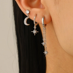 Macro shot of silver moon and star earrings set with dangling chains and zircon details