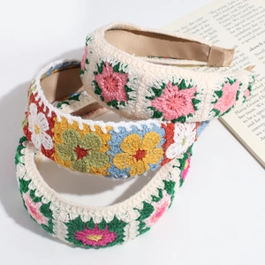 Detailed close-up of three handmade granny square crochet headbands with floral patterns