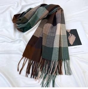 Close-up of thick plaid scarf with soft fringe edges and classic checkered pattern