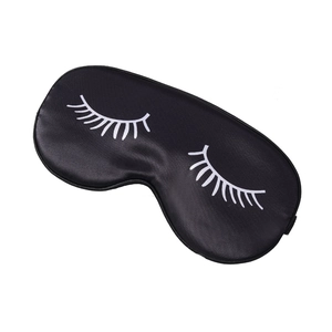 Black satin sleep eye mask featuring white eyelash print on a clean white background