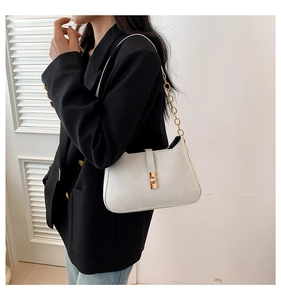 Close-up of white PU handbag with elegant gold metal chain and vintage lock detail
