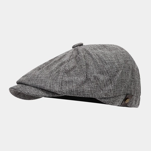 Close-up of newsboy cap with grey woven texture and leather strap detail