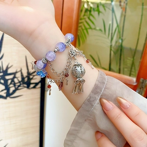 Detailed close-up of a vintage Chinese style purple beaded bracelet with hollow tassel charms
