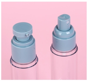 Close-up of gray-blue pump and spray heads on clear plastic travel bottles