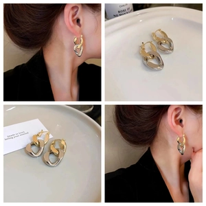 Minimalist chain link earrings in gold and silver tones worn by a female model