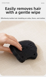 Detail of cat-shaped sponge removing pet hair from fabric surface in washing machine