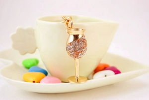 Detail of creative gold wine glass keychain with sparkling crystal rhinestones and metal clasp