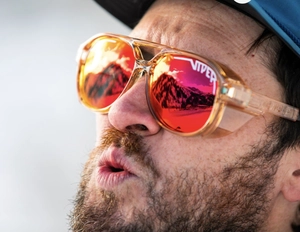 Close-up of polarized sports sunglasses with red mirrored lenses and mountain reflection