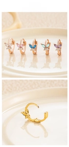 Detail of colorful butterfly zircon huggie earrings in rose gold plating with five colors