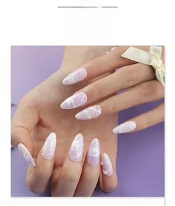 Detail of luxury 3D white swan press-on nails with lace patterns and pearl bows