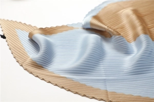 Close-up of plissé pleated scarf showing light blue and gold silk texture