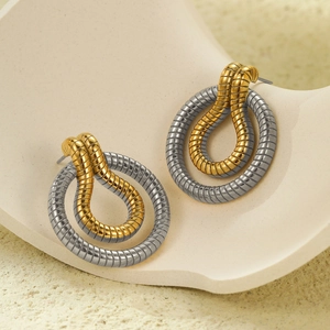 Detail of twisted stripe earrings in 18K gold and silver two-tone stainless steel finish