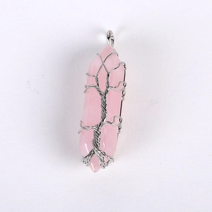 Macro shot of silver wire-wrapped pink crystal hexagonal pendant with life tree detail