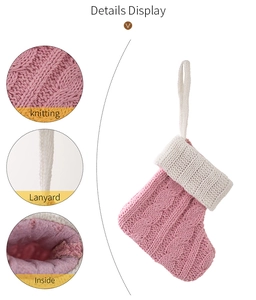 Detail view of pink knitted Christmas stocking showing cable pattern and sturdy lanyard