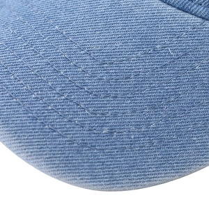 Macro shot of blue washed denim baseball cap brim with precise six-row stitching detail