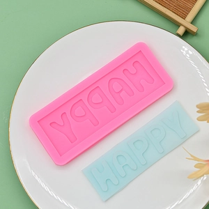 Silicone happy letter fondant mold for DIY cake decorating and clay crafts on ceramic plate