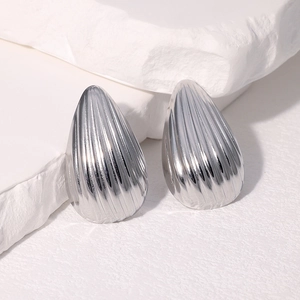 Boucles d'oreilles gouttes argentées minimalistes avec rayures sur socle blanc