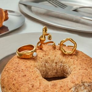 Minimalist gold plated stainless steel irregular rings with pearls on creative background