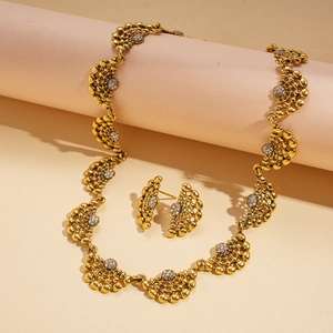 Détail d'un ensemble collier et boucles d'oreilles en éventail doré serti de cristaux