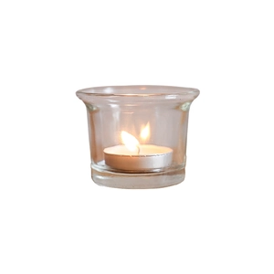 Minimalist transparent glass candle holder with a burning white tea light on white background