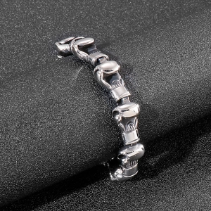 Detailed macro view of silver-tone boxing glove links on a chunky stainless steel bracelet
