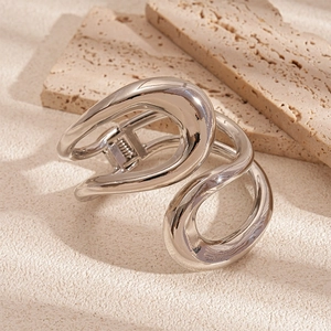 Detail view of a minimalist silver metallic hair clip with a sleek curved geometric design