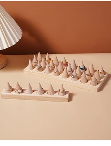 Detail of wooden cone ring holders on a rectangular base for jewelry organization
