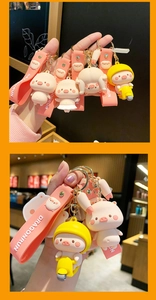 Detail of pink silicone piggy keychains featuring helmets and motorcycles on straps