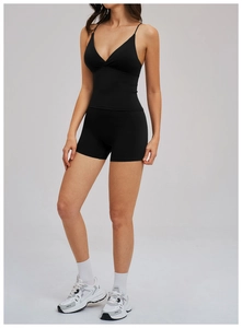Detail of black sports yoga set featuring high-waist shorts and V-neck tank top