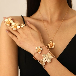 Detailed view of women's gold floral jewelry set including necklace, bracelet and rings