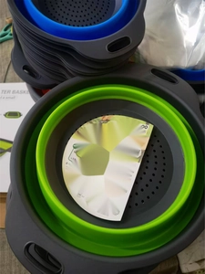 Close-up of small collapsible silicone colander in grey-green and blue stacked flatly
