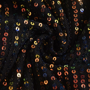 Gros plan sur tissu en maille noire avec paillettes multicolores et texture délicate