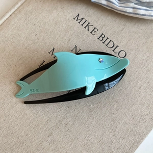 Detail of blue whale acrylic hair claw clip with star rhinestone and artistic texture