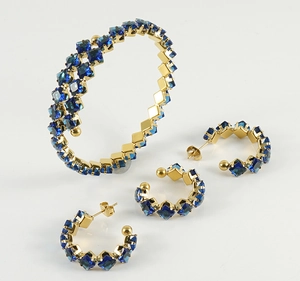 Macro shot of gold-plated jewelry set featuring elegant square-cut blue gemstones