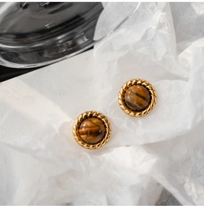 Close-up of vintage gold stud earrings with tiger eye stone and twisted rope texture