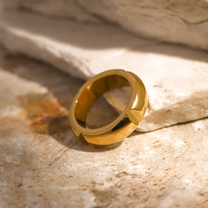 Polished 18k gold stainless steel ring resting on textured stone for a luxury look