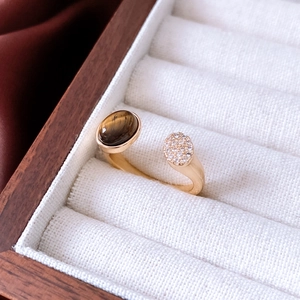 Detailed view of 18K gold plated tiger eye stone ring with zircons in a wooden box