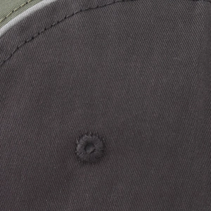 Close-up of embroidered eyelet on dark grey cotton twill minimalist baseball cap