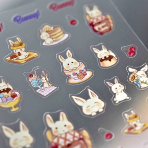 Macro shot of 5D nail art stickers with cute bunny, dessert and floral patterns