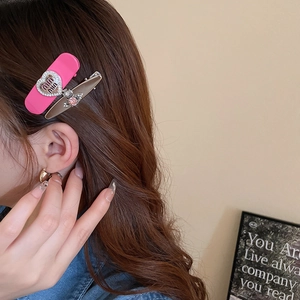 Detail view of heart-shaped rhinestone and star hair clip set on model's hair
