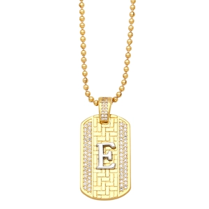 Detailed close-up of golden dog tag pendant with silver letter E and micro-set cubic zirconia