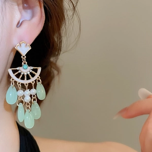 Detail of vintage style ginkgo fan earrings with pearls and green teardrop tassels