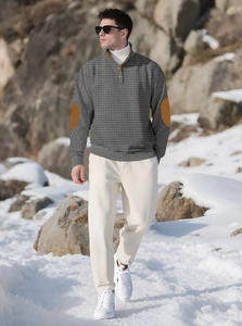 Detail of grey waffle-knit texture and brown elbow patches on men's long-sleeve sweater