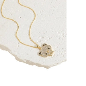 Golden necklace with emerald bear pendant encrusted with black and white zircon stones