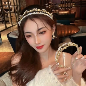 Close-up of golden double-layer headband with white pearls and sparkling rhinestones