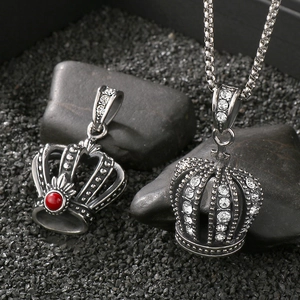 Macro shot of punk hip hop style crown pendants with red gemstone and clear rhinestones